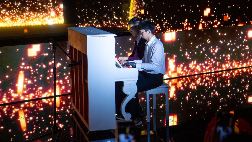 智能仿生手使用者古月與少年鋼琴家舒海峰合奏。主辦方供圖