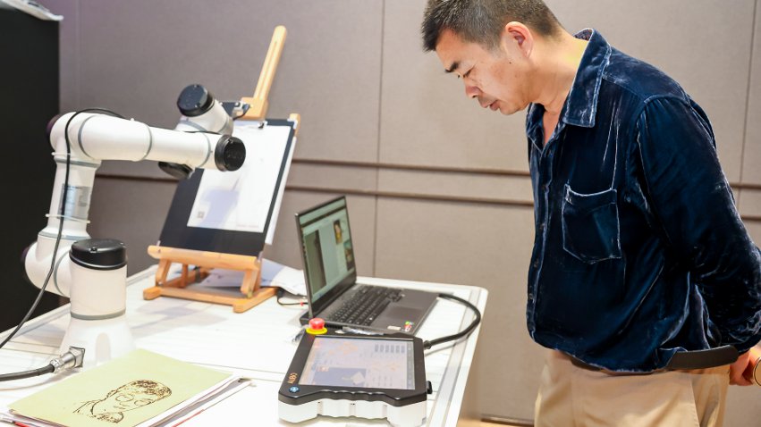 嘉賓體驗(yàn)遨博AI繪畫(huà)機(jī)器人。主辦方供圖